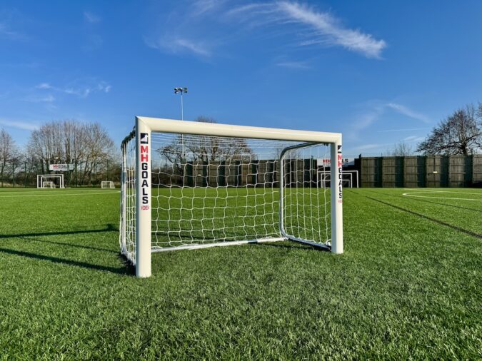 Small goal in the middle of a pitch under blue skies